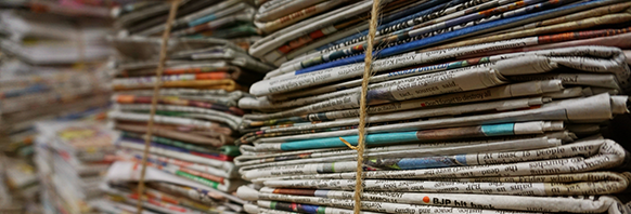 This is the Press Releases section with an image of multiple stacks of newspapers tied together